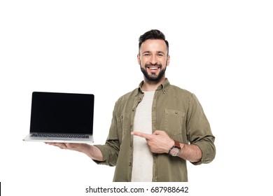 Portrait Of Smiling Man Pointing At Laptop With Blank Screen Isolated On White