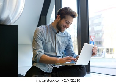 Portrait Of A Smiling Man Using Laptop