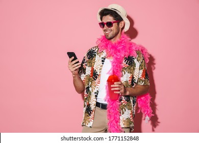 Portrait of smiling man wearing boa using cellphone while drinking soda isolated over pink background - Shutterstock ID 1771152848