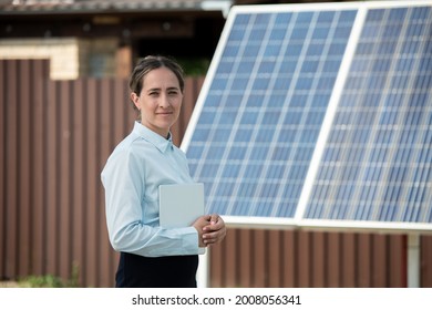 Portrait Of Smiling Manager Of Solar Panel Installation Company With Tablet Computer Standing Outdoors