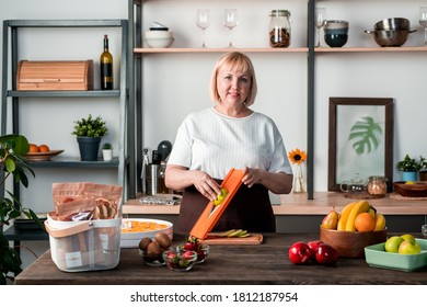 Portrait Of Smiling Mature Food Blogger Standing At Counter And Using Slicer While Cooking At Home Kitchen