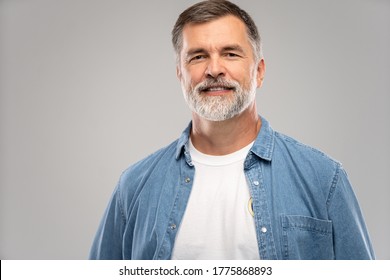 Portrait Of Smiling Mature Man Standing On White Background.