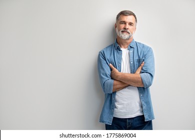 Porträt eines lächelnden reifen Mannes, der auf weißem Hintergrund steht.