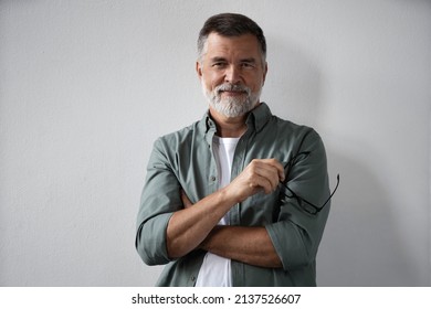 Portrait Of Smiling Mature Man Standing On White Background