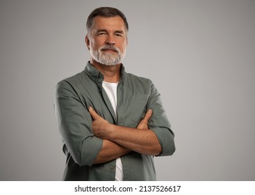 Portrait Of Smiling Mature Man Standing On White Background