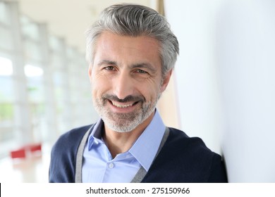 Portrait Of Smiling Mature Man Standing In Corridor