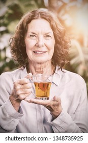 Portrait Of Smiling Mature Woman Drinking Herbal Tea, Close-up