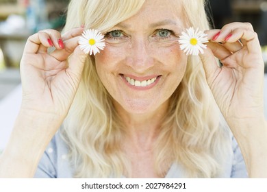 Portrait Of Smiling Mature Woman With Flowers. Natural Skin Care. Female And White Daisies. Organic And Healthy Lifestyle. Natural Make Up. Beauty Of Aging. Facial Caring