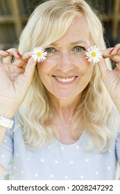 Portrait Of Smiling Mature Woman With Flowers. Natural Skin Care. Female And White Daisies. Organic And Healthy Lifestyle. Natural Make Up. Beauty Of Aging. Facial Caring