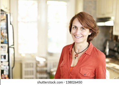 Portrait Of Smiling Mature Woman In Kitchen At Home