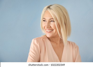 Portrait Of Smiling Mature Woman On Color Background