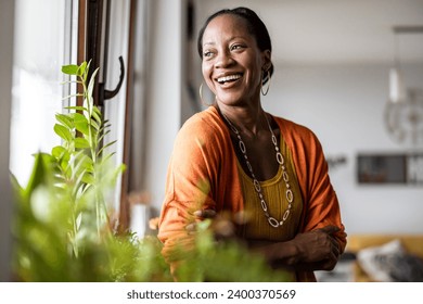 Portrait of a smiling mature woman standing in her apartment - Powered by Shutterstock