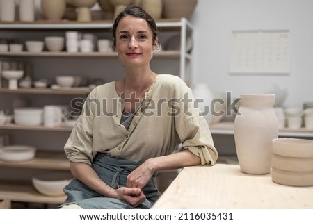 Similar – Woman in work wear in her workshop by table with handmade items