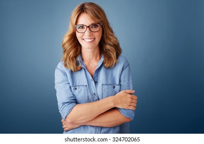 Portrait Of Smiling Middle Age Woman Wearing Casual Clothing While Standing Against Isolated Background And Looking At Camera. 