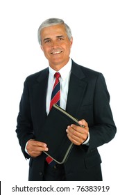 Portrait of a smiling middle aged business man holding a small binder with both hands. Vertical format isolated on white.