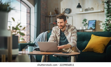 Portrait of Smiling Middle Aged Man Working from Home on a Laptop Computer in Sunny Cozy Apartment. Successful Male Entrepreneur Does Remote for e-Business Project, Online Shopping - Powered by Shutterstock