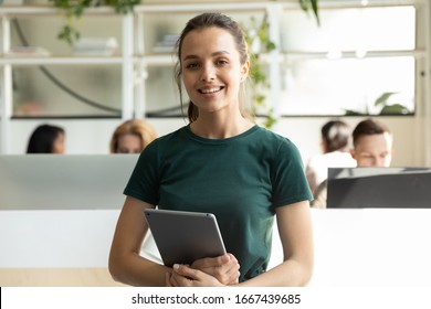 Portrait Of Smiling Millennial Caucasian Girl Graphic Designer Pose Holding Modern Tablet, Profile Picture Of Happy Young Female Employee Worker Stand With Pad In Coworking Office, Internship Concept