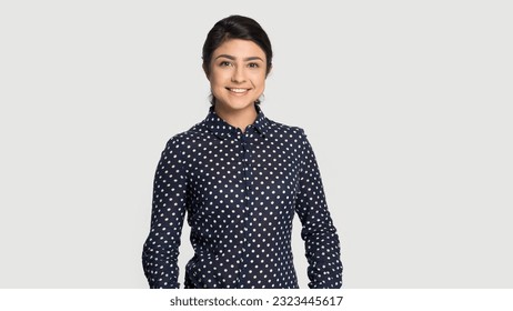Portrait of smiling millennial ethnicity female stand isolated on grey studio background. Happy young Indian woman in trendy fashion clothes feel confident. Employment, style concept.
