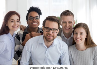 Portrait Of Smiling Millennial Multiracial Office Workers Posing Together, Diverse Young Business People Standing Looking At Camera, Team Of Professionals Show Support And Unity. Teamwork Concept