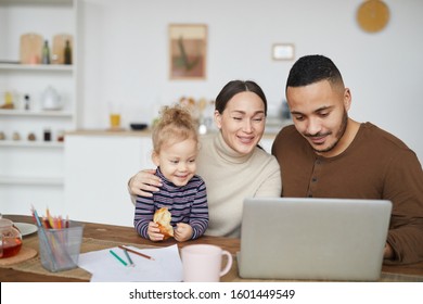 Portrait Of Smiling Mixed Race Family Using Laptop Together While Shopping Online, Copy Space