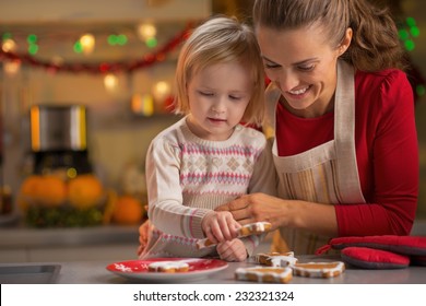 Portrait Of Smiling Mother And Baby Making Christmas Cookies