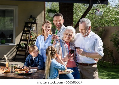 Portrait of smiling multi-generational family having picnic on patio at daytime - Powered by Shutterstock