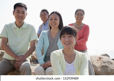 Portrait Of Smiling Multigenerational Family Sitting On The Rocks Outdoors, China