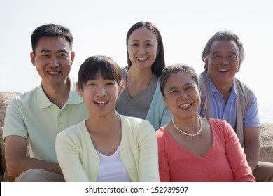 Portrait Of Smiling Multigenerational Family Sitting On The Rocks Outdoors, China