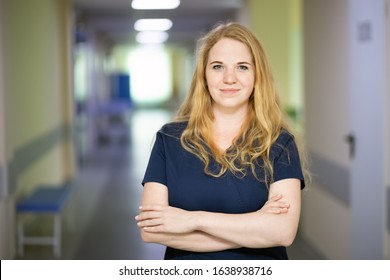 Portrait Of Smiling Nurse In Hospital Hallway