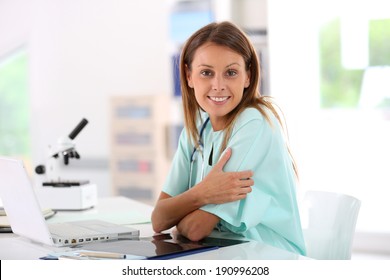 Portrait Of Smiling Nurse Studying On Laptop Computer