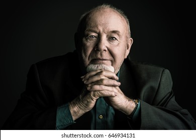 Portrait Of A Smiling Old Man Over Black Background. Old Age Concept.