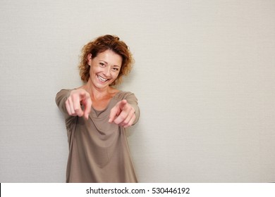 Portrait Of Smiling Older Woman Pointing Fingers