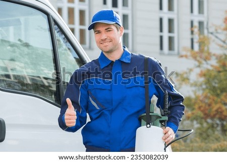 Portrait of smiling pest control worker showing thumbsup while standing by truck
