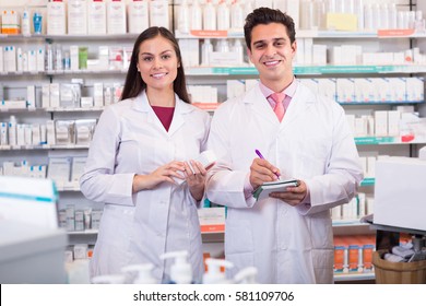 Portrait Of Smiling Pharmacist And Pharmacy Technician Posing In Drugstore