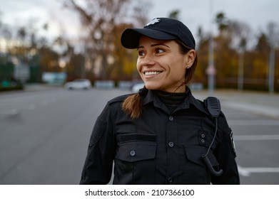 Portrait of smiling police woman on street - Shutterstock ID 2107366100