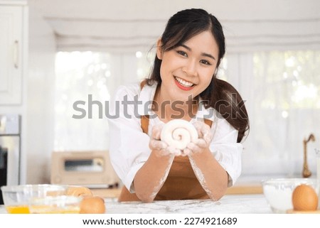 Portrait of smiling professional beauty asian woman chef having fun cooking with dough for homemade bake cookie and cake ingredient on table in kitchen