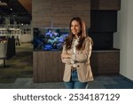 Portrait of smiling professional confident businesswoman standing with arms crossed at corporate office and looking away.Successful female manager posing at enterprise.Entrepreneur at posing at office