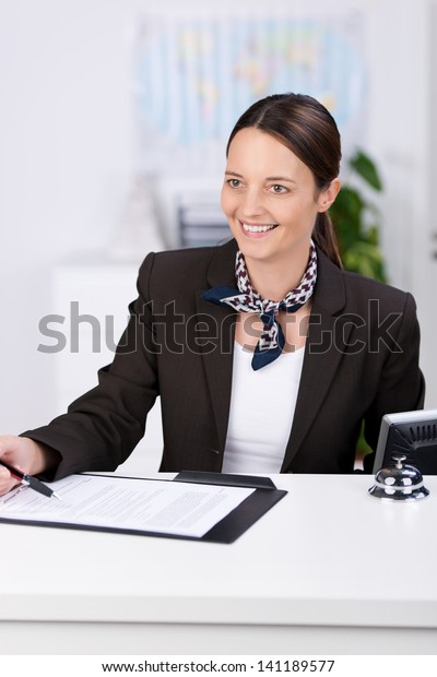 Portrait of\
smiling receptionist at counter in\
office