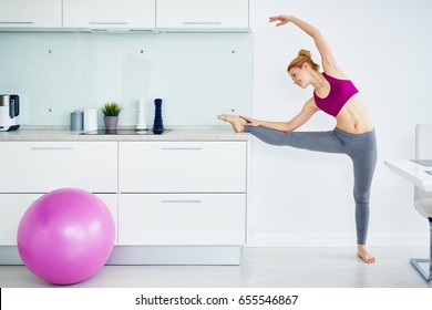 Portrait Of Smiling  Red Haired Woman Doing Fitness Ballet At Home, Stretching Leg Muscles