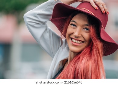 portrait of smiling redhead girl in hat outdoors on the street
