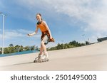 Portrait of smiling redhead teenager girl on roller skates at skate park in the city. Summer time concept