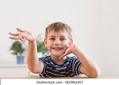 Portrait Of Smiling School Kid Waving Hand, Looking At Camera, Making Video Call Or Recording Video Vlog To Webcam At Home. 