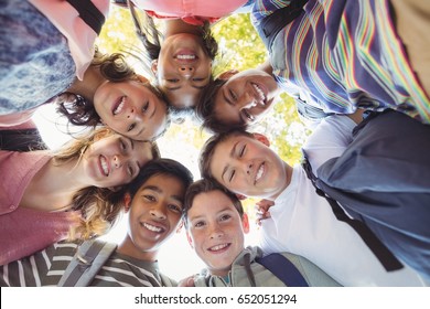 Portrait Of Smiling School Kids Forming A Huddle In Campus At School