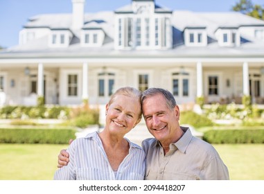 Portrait Of Smiling Senior Couple In Front Of House