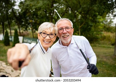 Portrait Of Smiling Senior Couple On Golf Course Enjoy Watching The Game Tournament.