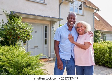 Portrait Of Smiling Senior Couple Standing Outside Home Together