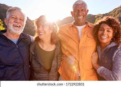 Portrait Of Smiling Senior Friends Walking In Countryside Together