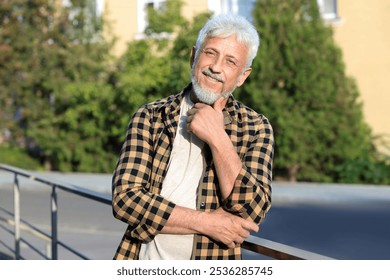 Portrait of smiling senior man in checkered shirt outdoors - Powered by Shutterstock