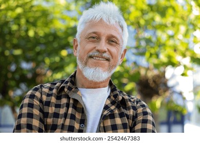 Portrait of smiling senior man in checkered shirt outdoors - Powered by Shutterstock