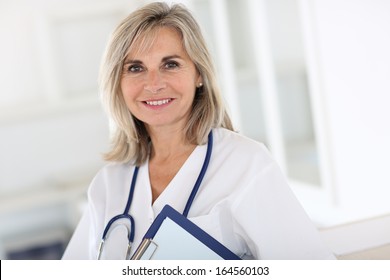 Portrait Of Smiling Senior Nurse In Hospital